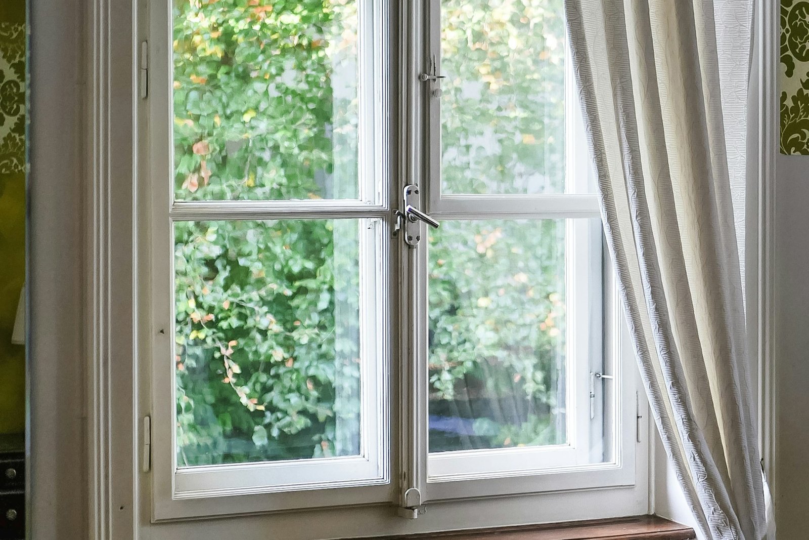 Fensterscharnier an einem geöffneten Fensterrahmen